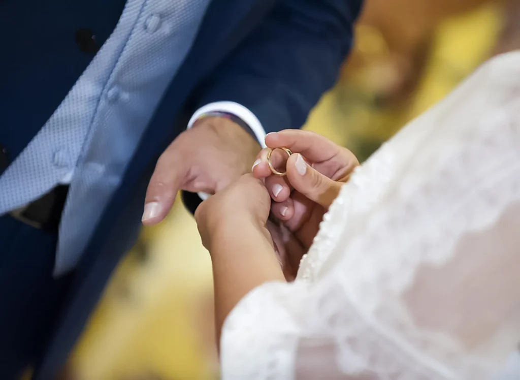 Scambio delle fedi nuziali durante la cerimonia di matrimonio, simbolo di promessa e unione