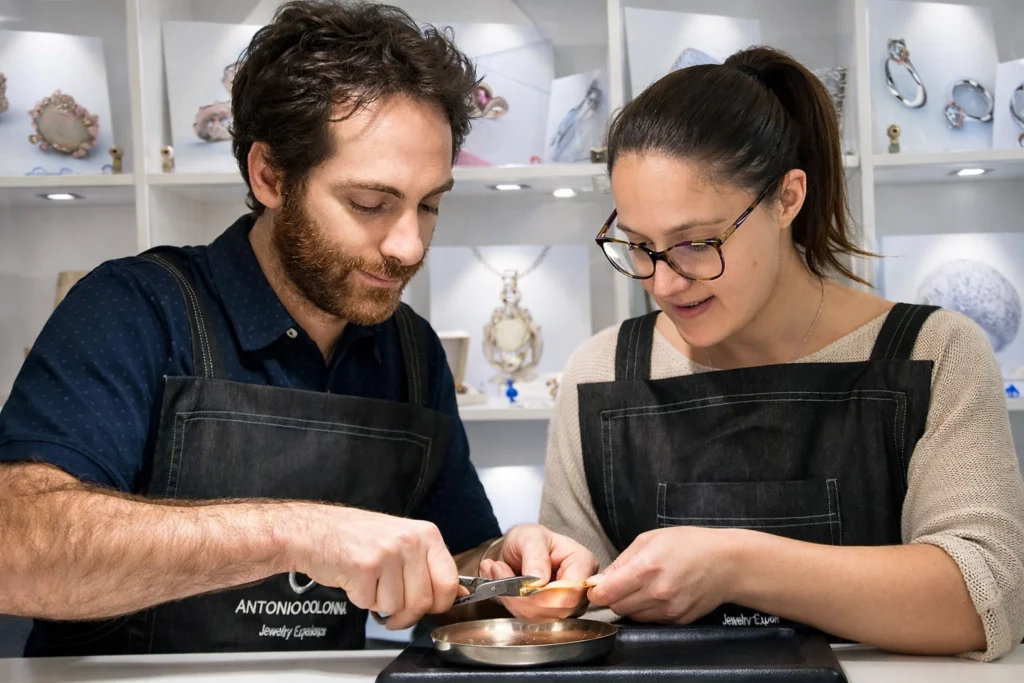 A couple being guided while crafting their wedding rings in a goldsmith's workshop