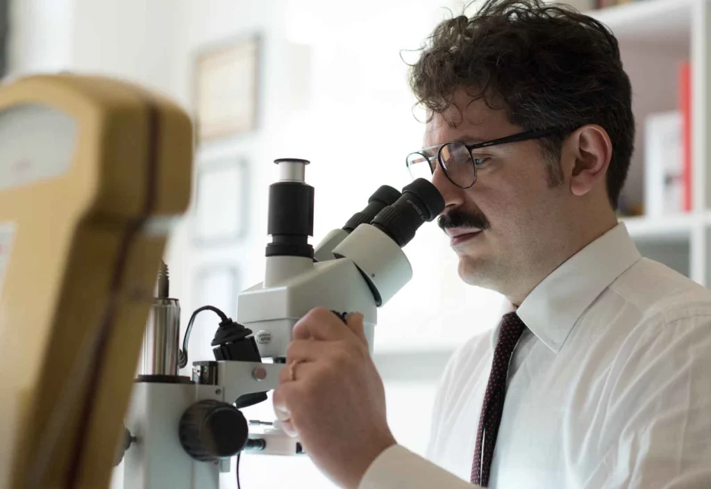 Perito gemmologo mentre analizza un diamante al microscopio nel laboratorio orafo Antonio Colonna.