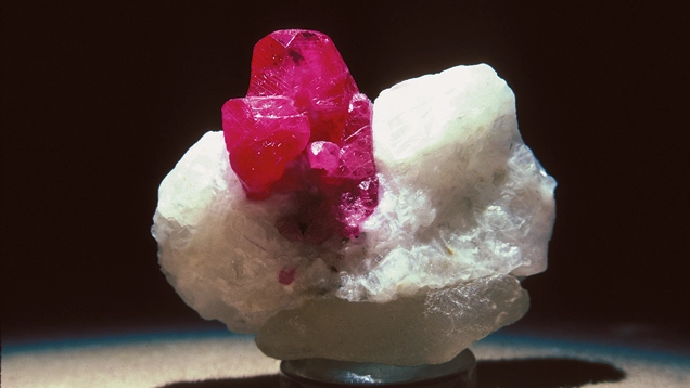 Raw red ruby crystals on white matrix